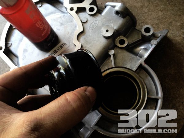 Timing cover front seal shown. Use an oil filter wrench to evenly distribute pressure while setting the seal.